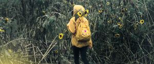 Preview wallpaper man, field, flowers, backpack, clouds, overcast