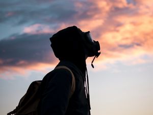 Preview wallpaper man, gas mask, sunset, sky