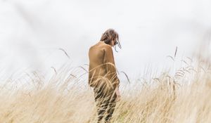 Preview wallpaper man, grass, loneliness, spikelets, field