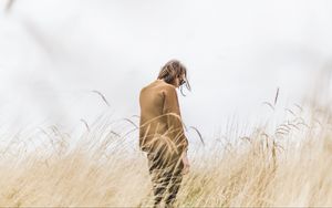 Preview wallpaper man, grass, loneliness, spikelets, field