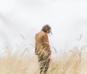 Preview wallpaper man, grass, loneliness, spikelets, field