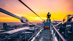 Preview wallpaper man, height, skyscraper, overview, city, sunset