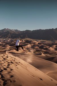 Preview wallpaper man, jump, desert, dunes, sand