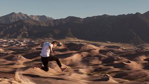 Preview wallpaper man, jump, desert, dunes, sand