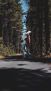 Preview wallpaper man, jump, levitate, road, trees, forest