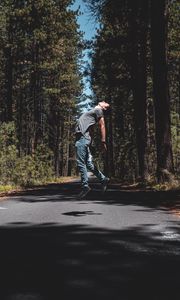 Preview wallpaper man, jump, levitate, road, trees, forest