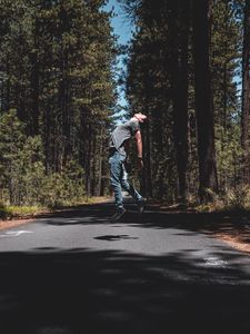 Preview wallpaper man, jump, levitate, road, trees, forest