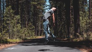 Preview wallpaper man, jump, levitate, road, trees, forest