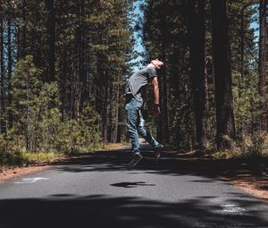 Preview wallpaper man, jump, levitate, road, trees, forest