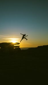 Preview wallpaper man, jump, rocks, sunset