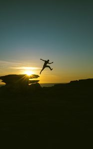 Preview wallpaper man, jump, rocks, sunset