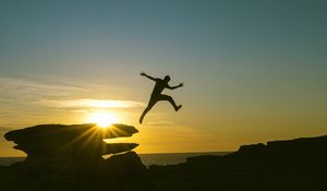 Preview wallpaper man, jump, rocks, sunset