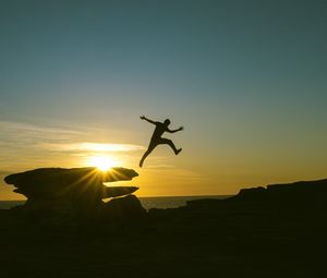 Preview wallpaper man, jump, rocks, sunset