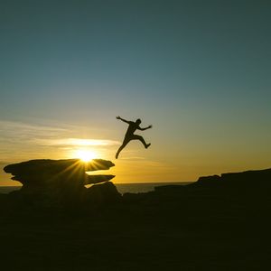 Preview wallpaper man, jump, rocks, sunset