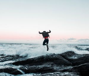 Preview wallpaper man, jump, waves, stones, sea