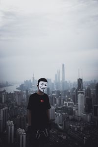 Preview wallpaper man, mask, city, buildings, view, overview