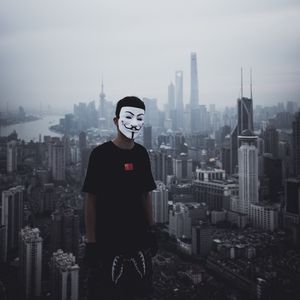 Preview wallpaper man, mask, city, buildings, view, overview