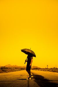 Preview wallpaper man, person, umbrella, road, sunset
