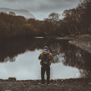 Preview wallpaper man, pond, cloudy, trees, gloomy