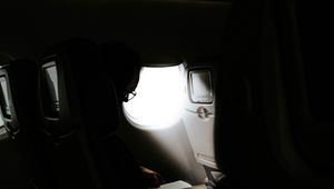 Preview wallpaper man, porthole, airplane, dark, rays