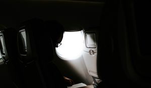 Preview wallpaper man, porthole, airplane, dark, rays