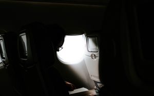 Preview wallpaper man, porthole, airplane, dark, rays