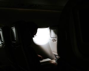 Preview wallpaper man, porthole, airplane, dark, rays