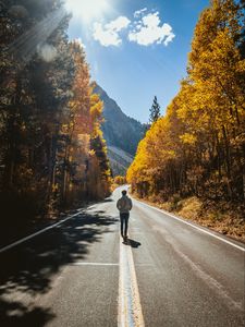 Preview wallpaper man, road, autumn, walk, loneliness, sunlight