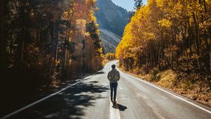 Preview wallpaper man, road, autumn, walk, loneliness, sunlight