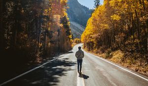 Preview wallpaper man, road, autumn, walk, loneliness, sunlight