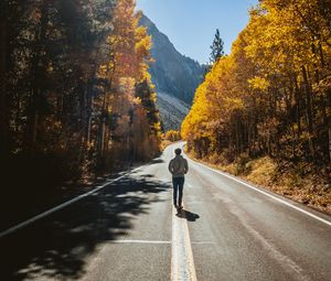 Preview wallpaper man, road, autumn, walk, loneliness, sunlight