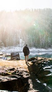 Preview wallpaper man, rocks, mountains, lake, sunlight, nature