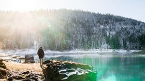 Preview wallpaper man, rocks, mountains, lake, sunlight, nature