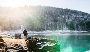 Preview wallpaper man, rocks, mountains, lake, sunlight, nature