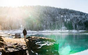 Preview wallpaper man, rocks, mountains, lake, sunlight, nature