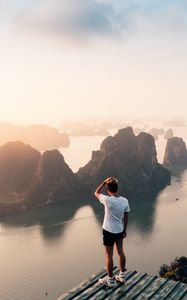 Preview wallpaper man, rocks, water, height, view, overview