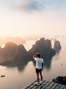 Preview wallpaper man, rocks, water, height, view, overview