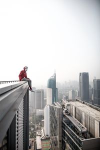 Preview wallpaper man, roof, city, buildings, height, overview