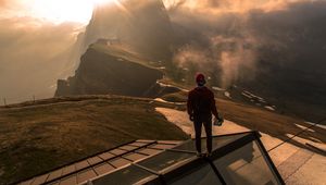 Preview wallpaper man, roof, mountains, height, clouds, fog, sunlight