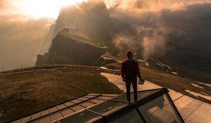 Preview wallpaper man, roof, mountains, height, clouds, fog, sunlight