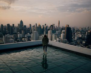 Preview wallpaper man, roof, water, city, horizon, wet, after rain