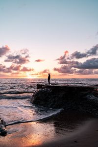 Preview wallpaper man, silhouette, alone, rock, sea, sunset