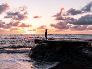 Preview wallpaper man, silhouette, alone, rock, sea, sunset