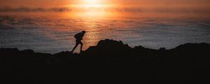 Preview wallpaper man, silhouette, alone, shore, water, sunset, dark