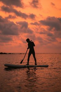 Preview wallpaper man, silhouette, alone, boat, water, sunset, dark