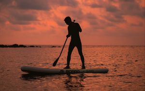 Preview wallpaper man, silhouette, alone, boat, water, sunset, dark