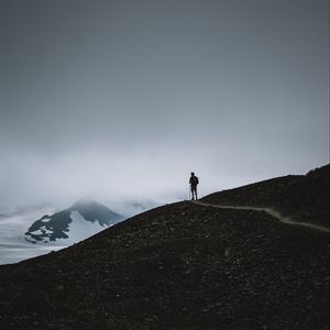 Preview wallpaper man, silhouette, alone, mountains, dusk, nature