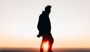 Preview wallpaper man, silhouette, dark, sunset, glare, twilight