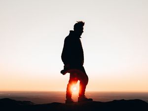 Preview wallpaper man, silhouette, dark, sunset, glare, twilight