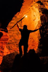 Preview wallpaper man, silhouette, fire, rocks
